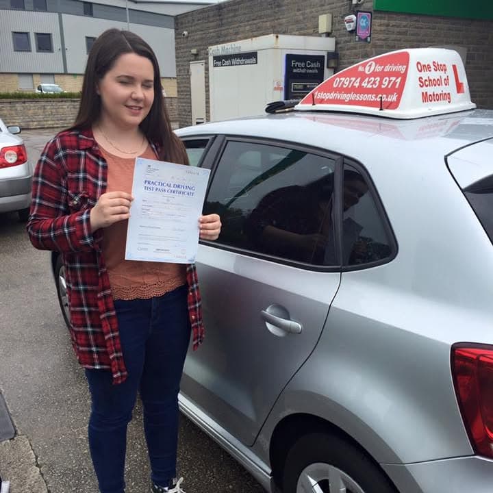 Newly passed learner holding their practical test pass certificate beside the One Stop School of Motoring car