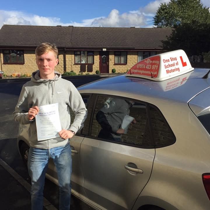 Newly passed learner holding their practical test pass certificate beside the One Stop School of Motoring car